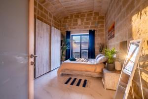 a bedroom with a bed in a room with a window at Fiftyfour West Boutique Living in Għarb