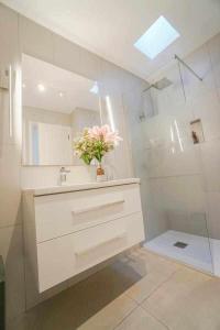 La salle de bains est pourvue d'un lavabo et d'une douche avec un vase de fleurs. dans l'établissement Los albaricoques, à Maspalomas