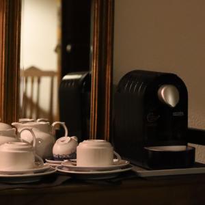 a group of tea cups and saucers on a table at Hotel Portofoz in Porto