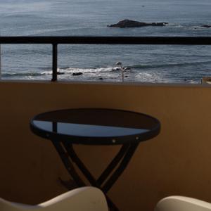 a table and chairs on a balcony looking at the ocean at Hotel Portofoz in Porto