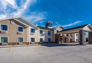 ein großes weißes Gebäude mit Parkplatz in der Unterkunft Cobblestone Inn & Suites - Holdrege in Holdrege