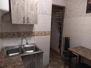 una cucina con lavandino, tavolo e doccia di Apartment on Sobornaya 58 a Chmel'nyc'kyj