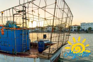 a boat is docked in the water at Cabanas Gardens by Algartur in Cabanas de Tavira