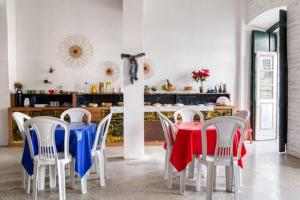 une salle à manger avec des chaises et une table avec des couvertures rouges et bleues dans l'établissement Pousada Cor e Arte - Pelourinho, à Salvador