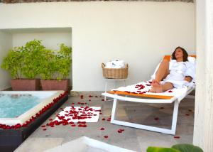 a woman sitting on a chair in front of a pool of water at Doña Urraca Hotel & Spa in Querétaro
