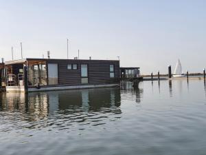 uma casa sobre uma doca sobre um corpo de água em Mermaid- Hausboote em Lelystad