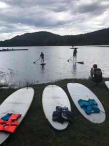 a group of people on paddle boards in the water at Cabañas Puerto Pireo in San Carlos de Bariloche