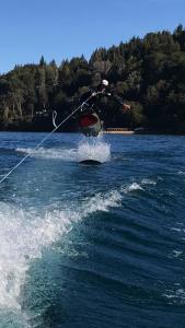 une personne fait du ski nautique sur un lac dans l'établissement Cabañas Puerto Pireo, à San Carlos de Bariloche