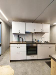 a kitchen with white cabinets and a stove top oven at Mermaid- Hausboote in Lelystad