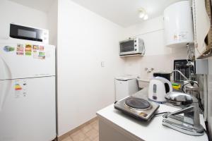 a kitchen with a white refrigerator and a sink at Apartamento Micro Centro para 4 con cochera in Bahía Blanca