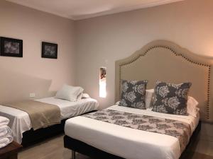 una habitación de hotel con 2 camas en una habitación en Hotel Galeria la Trinidad, en Cartagena de Indias
