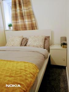 a bedroom with a bed with a yellow blanket on it at Sigma Central Apartment 2 in North Shields