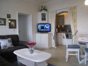 a living room with a couch and a table and a tv at Gästehaus Hoferichter, Whg 2 in Großenaspe