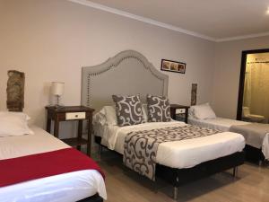 a hotel room with two beds and a bedskirts at Hotel Galeria la Trinidad in Cartagena de Indias