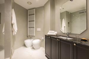 a bathroom with a toilet and a sink and a mirror at Missori Suites in Milan
