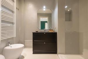 a bathroom with a sink and a toilet and a mirror at Missori Suites in Milan