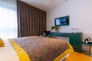 a bedroom with a bed and a desk and a television at Missori Suites in Milan