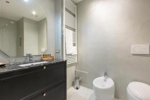 a bathroom with a sink and a toilet and a mirror at Missori Suites in Milan