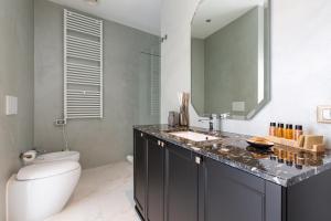 a bathroom with a toilet and a sink and a mirror at Missori Suites in Milan
