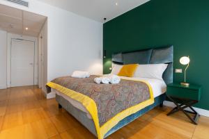 a bedroom with a large bed with a green wall at Missori Suites in Milan
