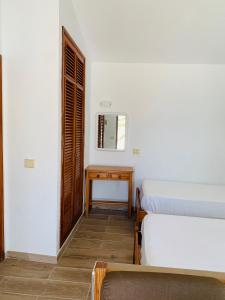 コティージョにあるCotillo Lagosのベッド2台、テーブル、鏡が備わる客室です。