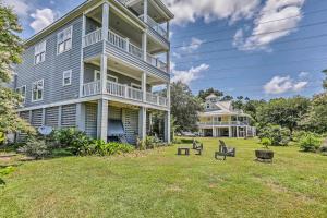 a large house with a yard with two chairs at Family Beach Home Walk to N Litchfield Beach in Pawleys Island