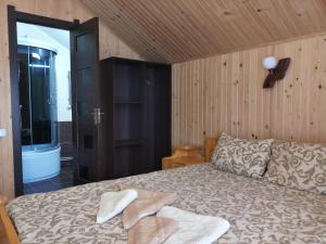 a bedroom with a bed with two towels on it at Затишний котедж "Хатинка" in Yablunytsya