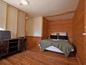 a bedroom with a bed and a flat screen tv at Auberge du Bachelard in Uvernet