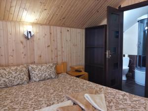 1 Schlafzimmer mit einem Bett und einem Bad in der Unterkunft Уютный котедж "Hatynka" in Jablunyzja