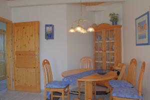 comedor con mesa de madera y sillas en Seestern Bungalow STW45b, en Dorum-Neufeld