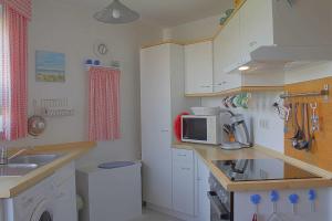 una pequeña cocina con fregadero y microondas en Seestern Bungalow STW45b, en Dorum-Neufeld