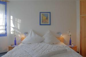 - un lit blanc avec des oreillers blancs dans une chambre dans l'établissement Seestern Bungalow STW45b, à Dorum Neufeld