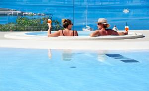 two women sitting in a bath tub in a swimming pool at Le Calette Bay in Cefalù