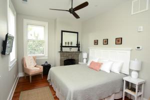 a white bedroom with a bed and a fireplace at 607 Bay Inn Downtown Beaufort in Beaufort