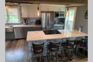 a kitchen with a large island with bar stools at Downeast Coastal Maine Escape! in Milbridge +29 photos