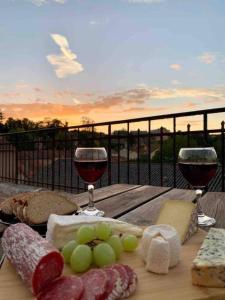 una mesa con dos copas de vino y queso en 2 bed apartment fantastic roof terrace-town centre, en Montmorillon