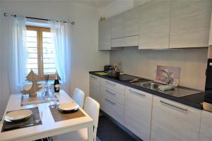 a kitchen with white cabinets and a table and a sink at Chalet Laghel in Arco