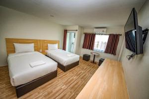 a hotel room with two beds and a flat screen tv at The charlotte smart hotel lopburi in Lop Buri