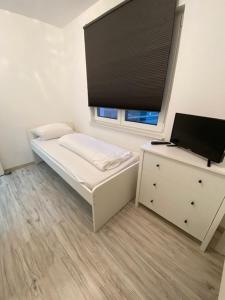 a small bedroom with a bed and a window at Ferienwohnung Anemone in Bahlingen