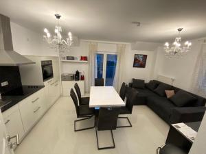a living room with a black couch and a table at Ferienwohnung Anemone in Bahlingen