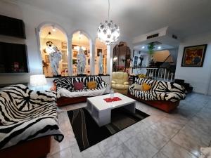 una sala de estar con sofás con estampado de cebra y una mesa. en Villa Matias Pool and beach, en Playa de Palma