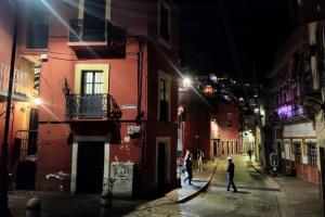Un gruppo di persone che camminano per strada di notte di Embajadoras Apartment & Rooftop a Guanajuato