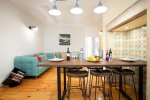 a living room with a table and a blue couch at Contador Mor Rooms and Apartments in Lisbon