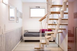 a spiral staircase in a room with a bed at World Village Apartments in Diano Marina