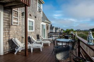 a deck with chairs and a table on a house at A Cape Cod Ocean Manor Inn in Hyannis
