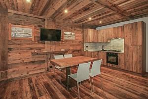 a wooden room with a wooden table and chairs at Snowflake Appartamenti Jouvenceaux in Sauze dʼOulx