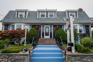 a house with blue stairs leading to the front door at A Cape Cod Ocean Manor Inn in Hyannis