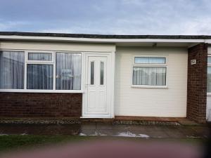 a house with a white door and two windows at alicias chalets in Great Yarmouth