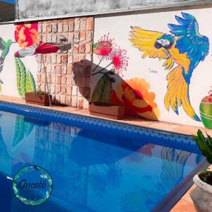 a mural next to a swimming pool at Oncotô Palmas Hostel in Palmas