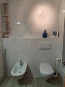 a white bathroom with a toilet and a sink at SeeStern Strandnahe Wohnung in Hohen Wieschendorf in Hohen Wieschendorf